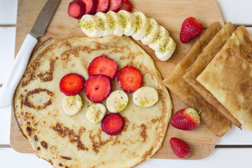 Pancakes filled with fresh strawberries and banana - 347623401