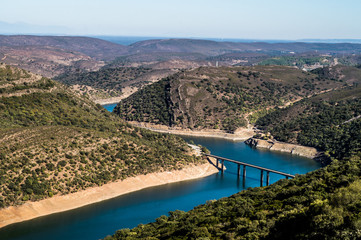 aerial view of a bridge over a river, for the passage of vehicles and people from one side of the valley to the other