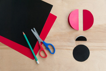 How to make cardboard colourful ladybird DIY. Homemade craft with ladybug tutorial. Glue, paper, scissors and pencil on a wooden table. Children's art project, a craft for children. Step two