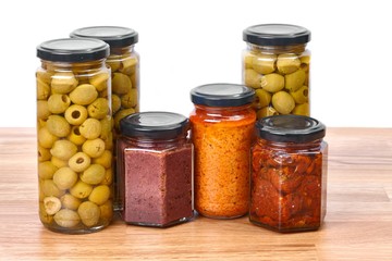 Jars of olives, pesto, dried tomatoes, caper on a shelf