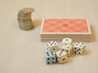Dados y baraja junto a monedas