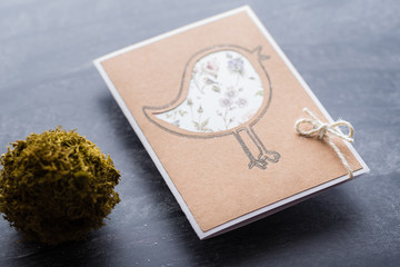 An empty greeting card design with pencil painted bird on a black backdrop