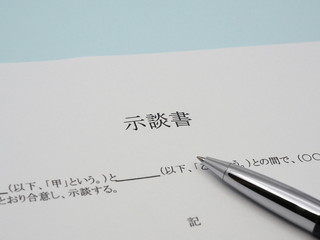 示談書とペン／水色背景