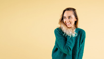 Amazement - woman excited looking to the side. Surprised happy young woman looking sideways in excitementl on yellow background