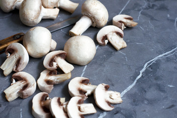 Sliced mushrooms champagne and knife on grey background