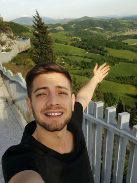 hansome guy taking a selfie in the highest point of the city