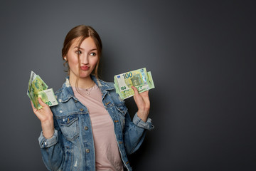 Portrait of a natural and authentic beautiful young woman, teenager with many 100 Euro banknotes in...