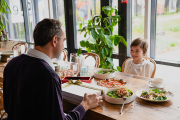 Father and son celebrating in a cafe