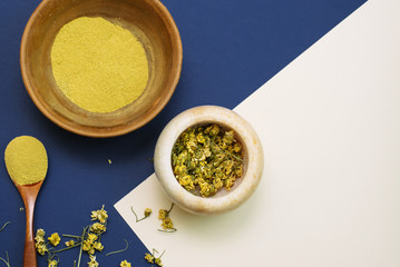 Mix dry chamomile flowers in a marble mortar to create cosmetics and a face scrub. Yellow clay to...