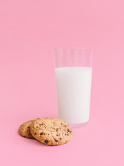 Cookies with milk Photo in minimal style Glass of milk and oatmeal biscuits on pink background in front view