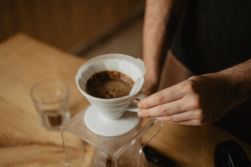 manos de hombre colocando un café de filtro v60 en una cafetería