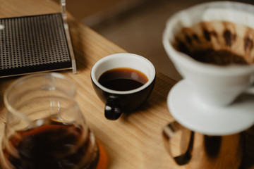 taza negra de café de de filtro v60 en una mesa de madera