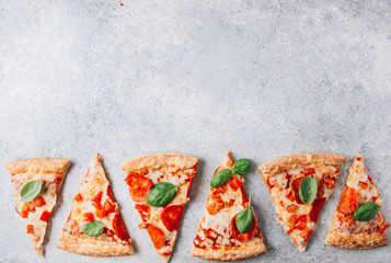 Slices pepperoni fresh pizza with basil on a light gray background. Top view . With copy space