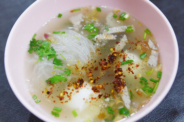 delicious noodles bowl - close up of vermicelli noodles soup spicy with pork egg and vegetable in bowl traditional thai and chinese style food of asia