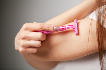 Woman doing hair removal on their hands at home in the bathroom