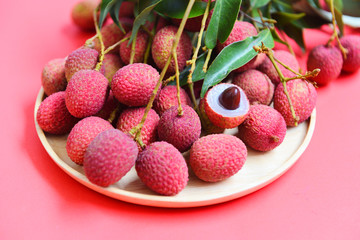 Lychee with green leaves harvest in wooden plate from tree tropical fruit