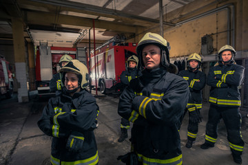 Group of firefighters standing confident with arms crossed. Firemen ready for emergency service.