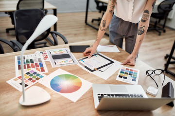 Graphic designer at work. Cropped view of tattooed female designer working on a new project while...
