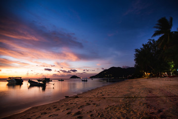 seascape at sunset with boats and colorful sky