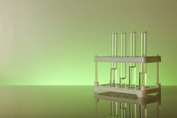 chemical test tube stand with flasks on green background with copy space