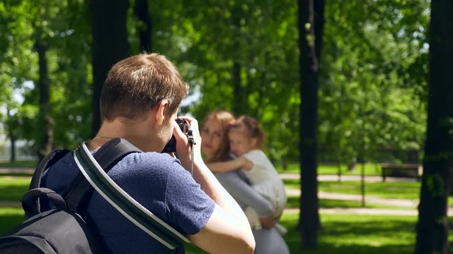 Photographer Shooting Taking Pictures of Mother with Child. Backstage Photo Session in City Park Background. 2x Slow motion 1/2 60 FPS
