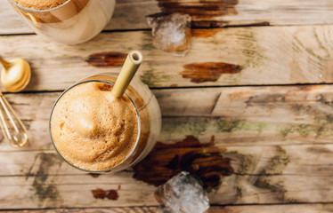 Iced frothy Dalgona Coffee, a trendy fluffy creamy whipped coffee. Korean drink latte espresso with coffee foam. made of instant coffee, sugar, hot water and milk.