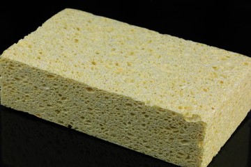 Cleaning and scrubbing sponge on a black background 
