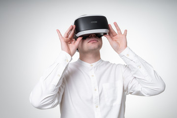 young man wearing vr glasses in white shirt