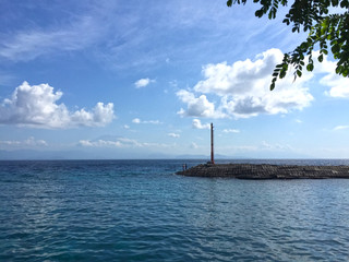 Sea and blue sky. Blue sea water and sky with white fluffy clouds. Horizontal background of blue sea. Tropical landscape