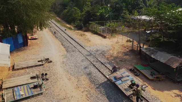 Locals disassembling top of Bamboo Train Norry Nori rail track, Cambodia, aerial view