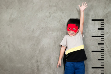 The boy in the superhero outfit smiled and raised his hand to show the growth, with a unit beside...