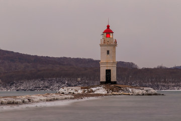 Dawn in the sea city of Vladivostok. Tokarevsky lighthouse during a colorful dawn against the backdrop of a beautiful sea.