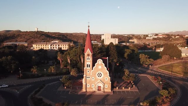 4K aerial drone summer sunset video of Windhoek old vintage Christuskirche red roof and sand stone Lutheran church in city center in Namibia's capital in central highland Khomas Hochland of Namibia