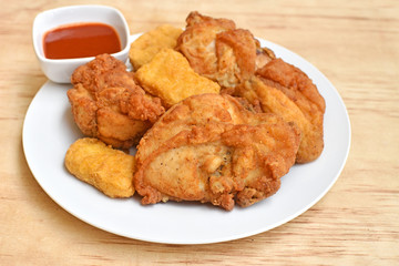 A plate of  crispy fried chicken on a wood table