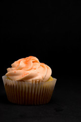 Delicious Muffin with Icing and Sugar on Dark Background