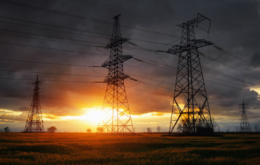 Silhouette High voltage electric towers at sunset time. High-voltage power lines. Electricity distribution station