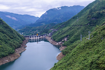 Obraz na płótnie Canvas Dam wall and surrounding landscape at Wulong Dam in Chongqing, China. during summer with a low water level on a clear sunny day.