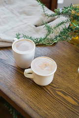 Two mugs of coffee on wood coffee table