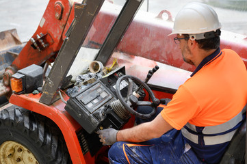 Construction worker starting the excavator machine . © herraez