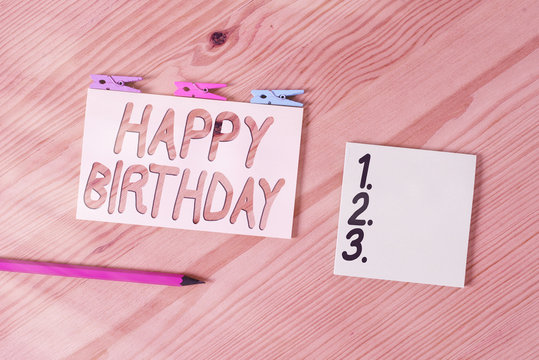Conceptual hand writing showing Happy Birthday. Concept meaning The birth anniversary of an individual is celebrated with presents Colored crumpled papers wooden floor background clothespin