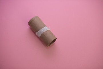 Empty roll of toilet paper isolated against pink background