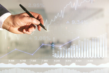 Multi exposure of trader hand with pen working with virtual abstract financial graph interface on...