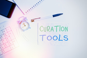 Handwriting text writing Curation Tools. Conceptual photo Software used in gathering information relevant to a topic Flat lay above computer mobile phone clock pencil and copy space note paper