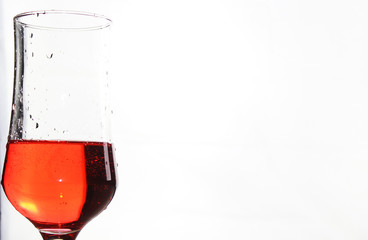 Glass with a red drink on a white background
