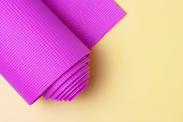 Pink sports mat on yellow background, top view, copy space