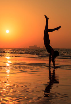 Woman Practicing Handstand At Beach Against Clear Sky During Sunset © maria feklistova/EyeEm