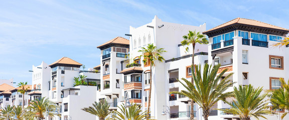 Living house with appartments and balconies in arabian style with sky background. Selective focus. Banner edition.