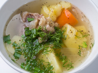 Shurpa soup. Beef with potatoes and carrots in a broth in a white bowl. Close-up