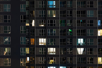 Fototapeta na wymiar Scenic windows of skyscrapers at night timelapse. People moving inside apartments.