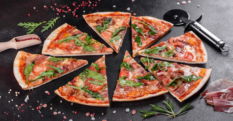 Fresh pizza baked in oven with arugula, salami, cherry tomatoes and mozzarella
